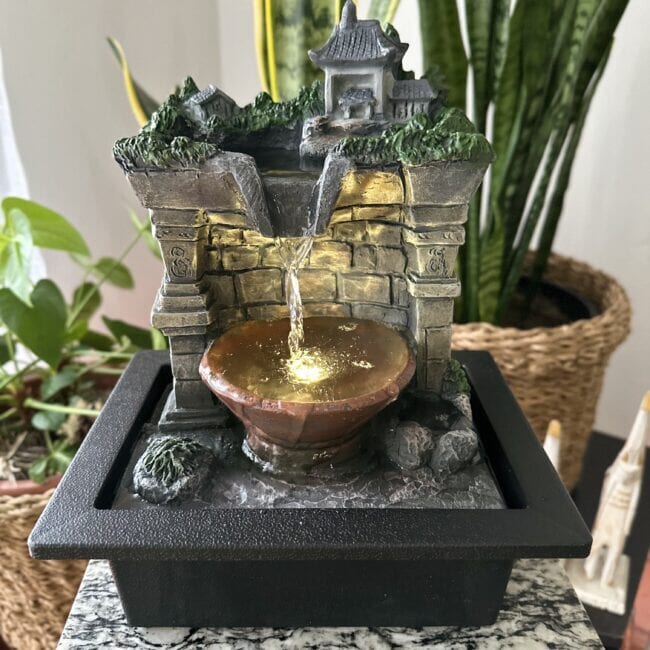 Fuente de agua con templo y bosque